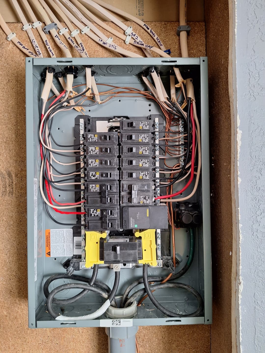 Interior electrical panel with labeled circuits, breakers, and organized wiring during installation.