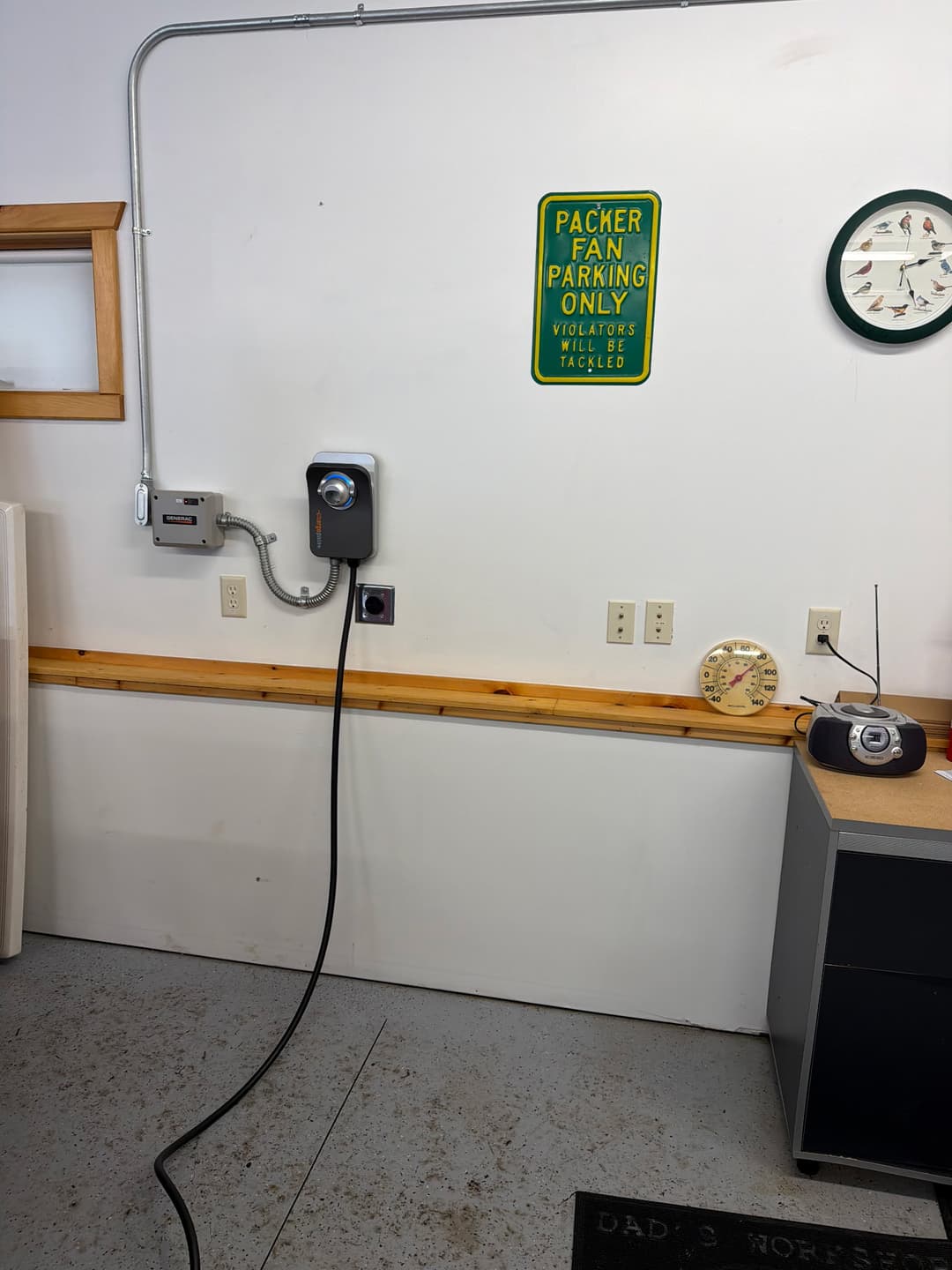 Generac transfer switch and ChargePoint EV charger installed together on an interior garage wall.