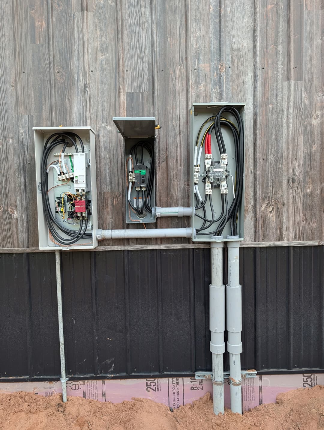 Exterior commercial electrical service equipment with open disconnects and control panel mounted on a pole building.