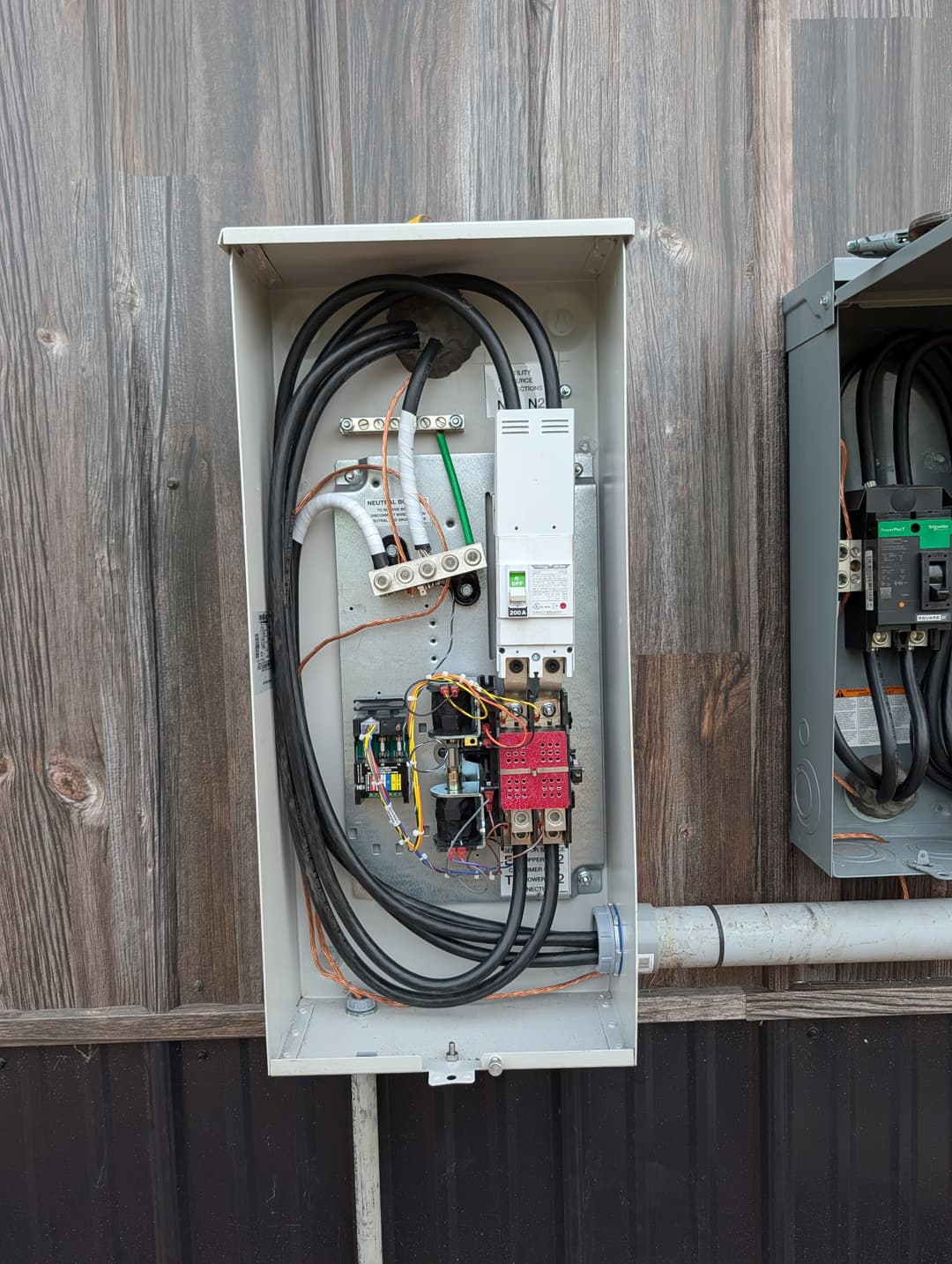 200A main breaker panel with neutral bus bar and organized wiring installed on an exterior commercial building.