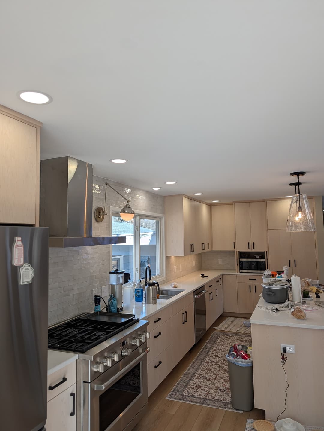 Remodeled kitchen with recessed ceiling lights, pendant island lighting, and under-cabinet lighting newly wired.