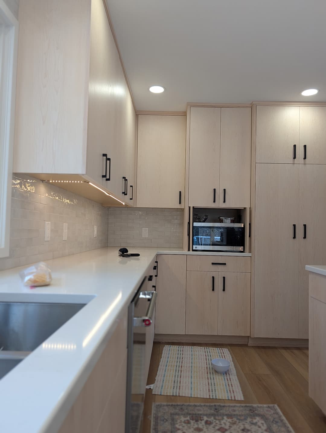 Recessed lighting and wiring for a built-in microwave completed in a remodeled kitchen.