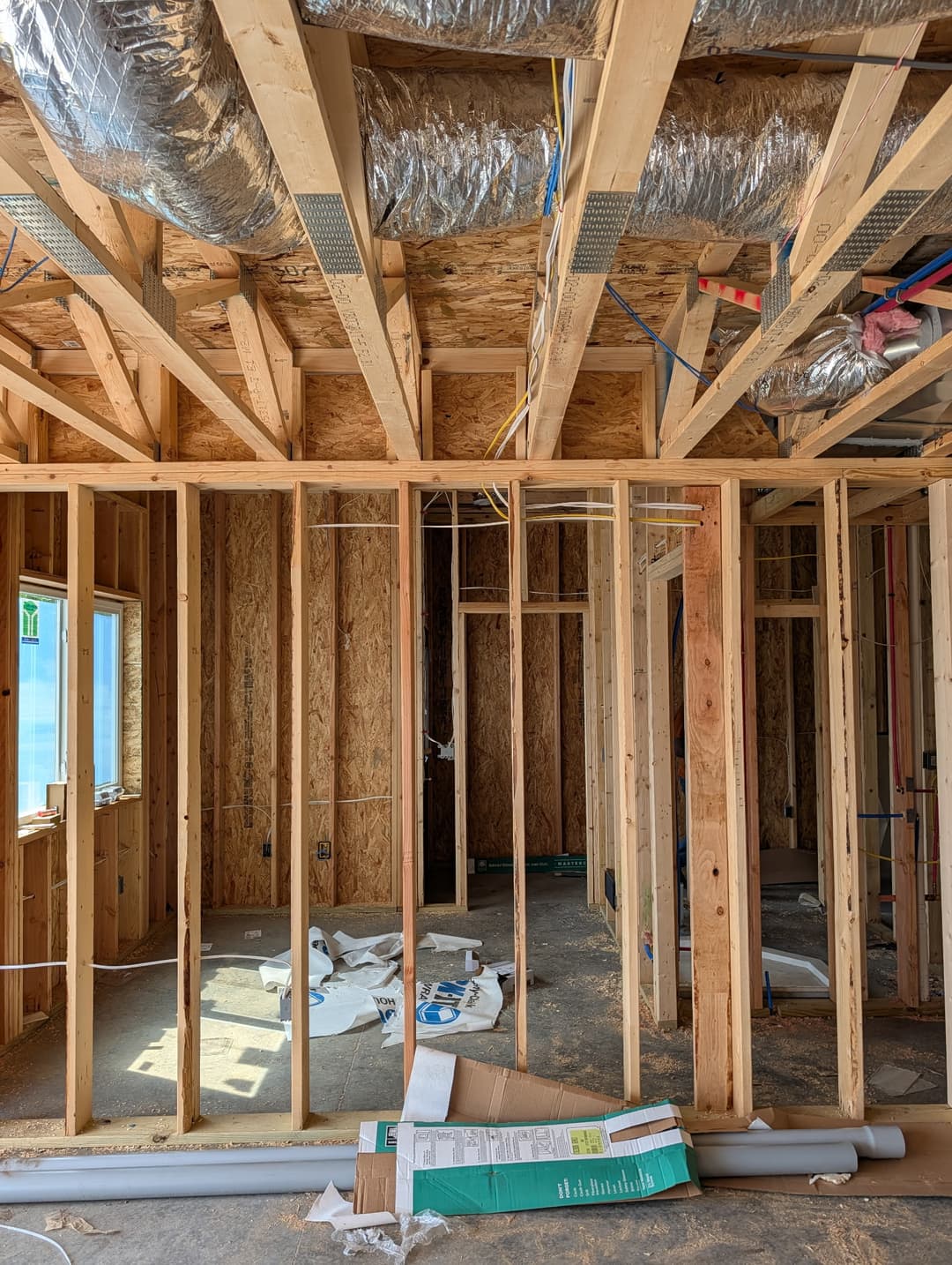 Electrical rough-in wiring routed near a window and exterior door opening during new home construction.