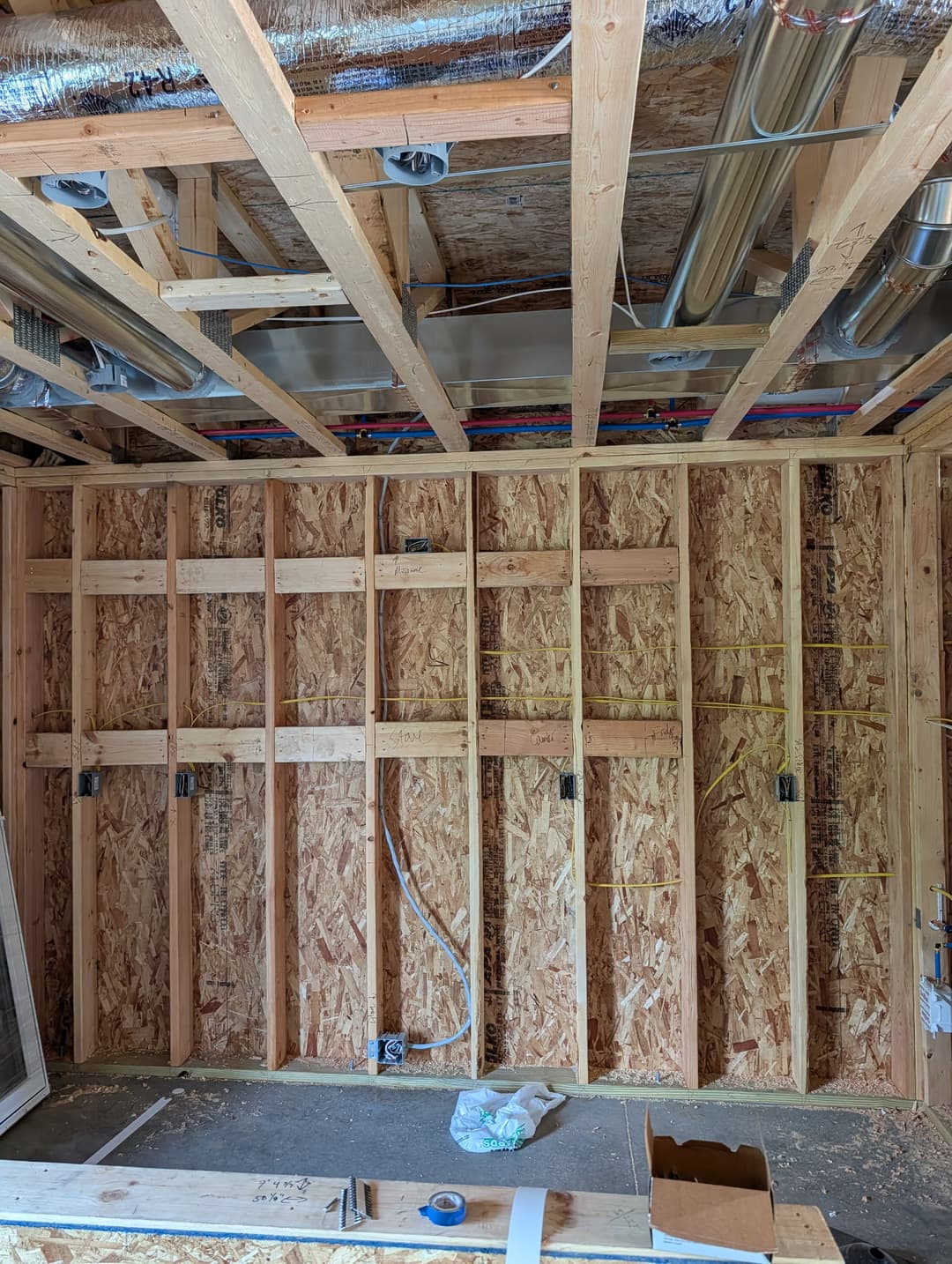 Outlet boxes and horizontal wire runs installed through wall studs during electrical rough-in.