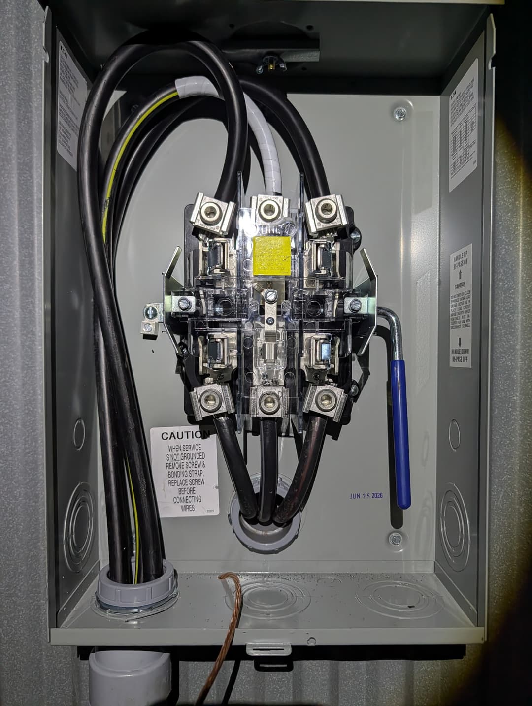 Close-up of meter socket lugs and bonding jumper installed in a new service enclosure.