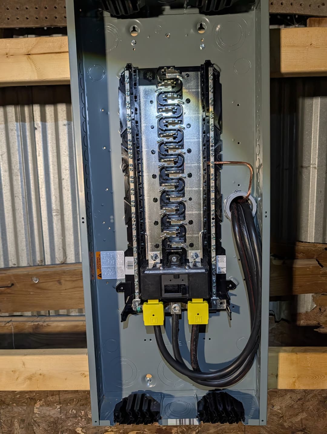 Main breaker panel installed and wired inside a pole building under construction.