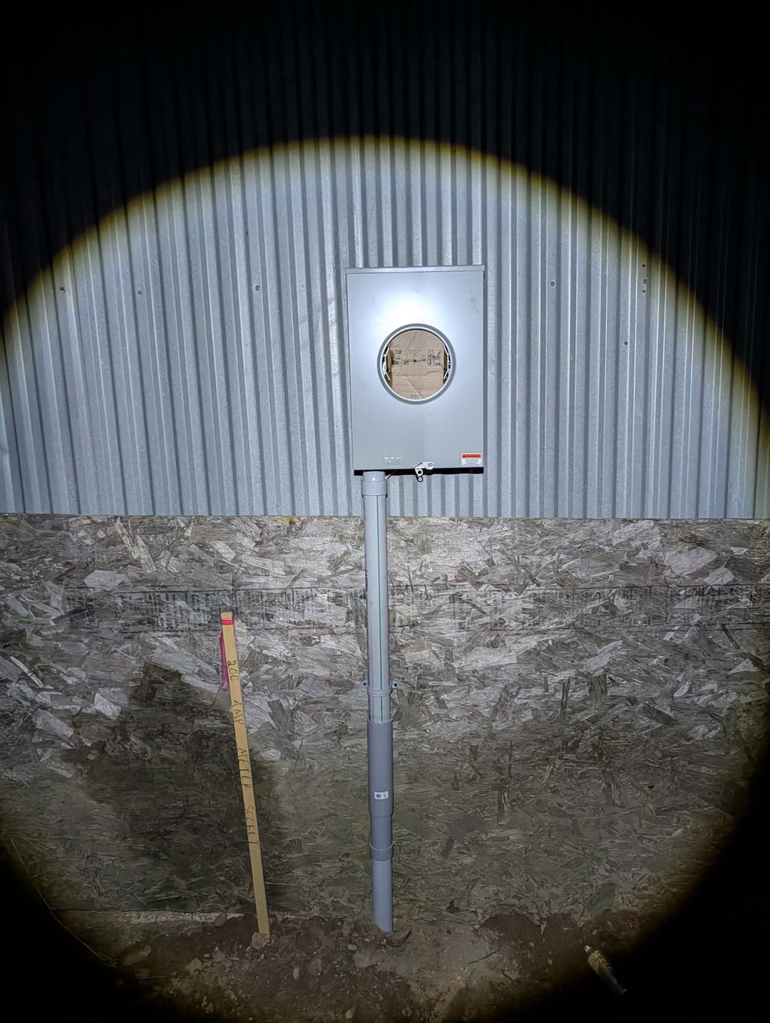 Meter enclosure and service riser installed on the exterior of a pole building.