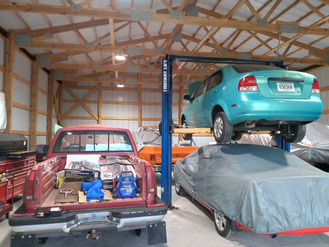 Two-post vehicle lift and shop equipment powered by newly installed electrical service in an auto repair shop.