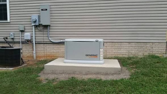 Standby generator installed on a concrete pad beside a home, wired and ready for automatic backup power